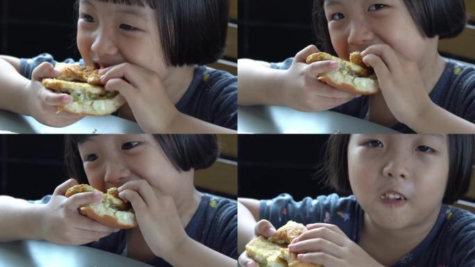 微笑的中国孩子吃美味的汉堡