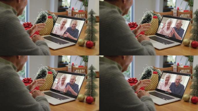 圣诞节时，快乐的高加索高级男子在笔记本电脑上与高级朋友进行视频通话