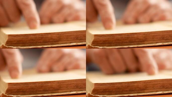 盲人主题学习和阅读旧书。盲人手指的特写沿着一本书的线条引导着文学。选择性聚焦，浅景深