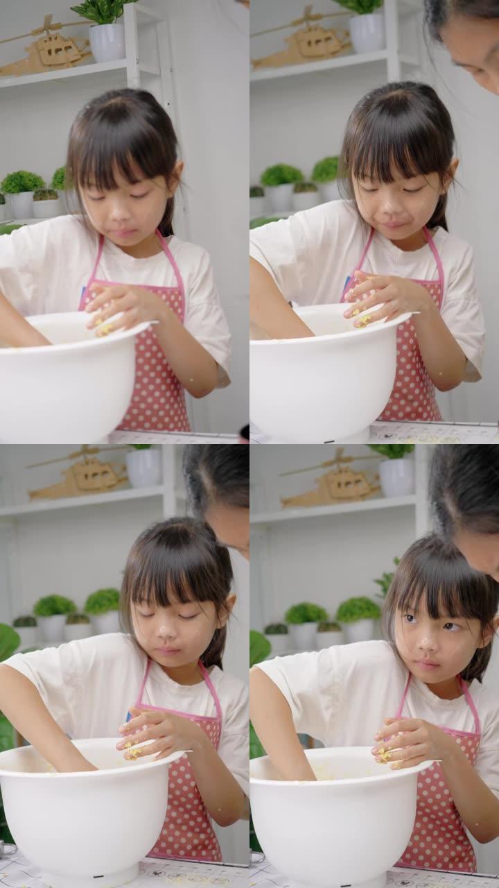 快乐的亚洲儿童在家学习制作饼干，女孩在搅拌碗中脱粒糕点面团。