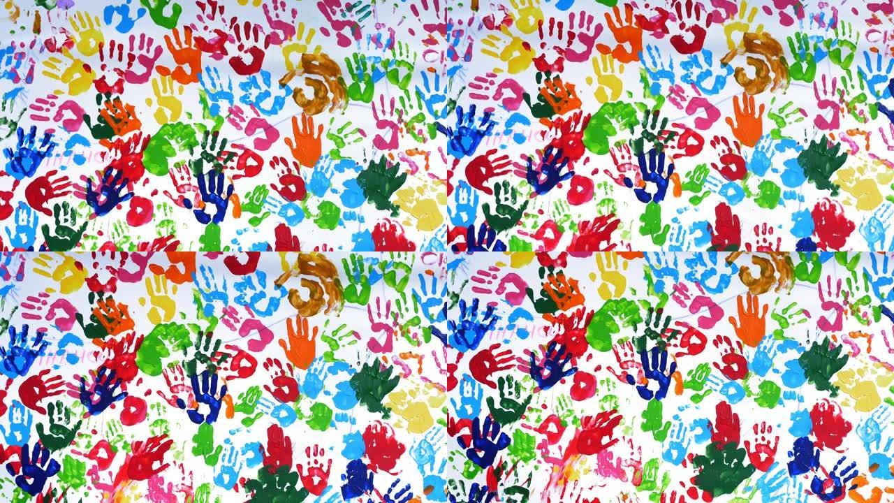 人类彩色手掌。彩色手印。特写。艺术。白色背景、白色墙壁或画布上的许多人类手掌的彩色印花