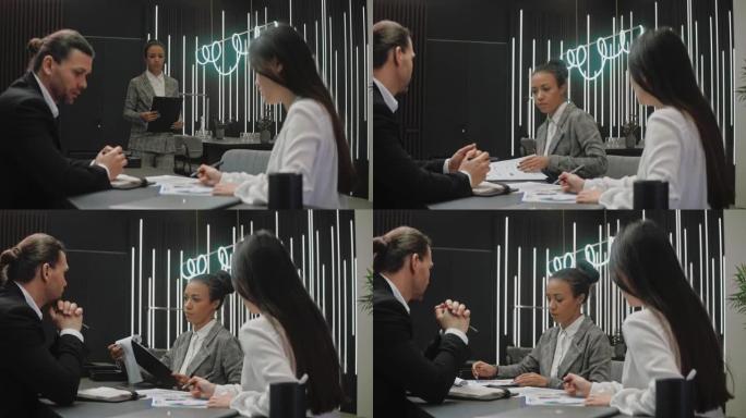 女人参加会议并与灰色办公室的同事分享信息