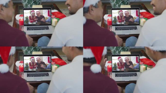带有圣诞老人帽子的混血儿父子使用笔记本电脑进行圣诞节视频通话，屏幕上有情侣