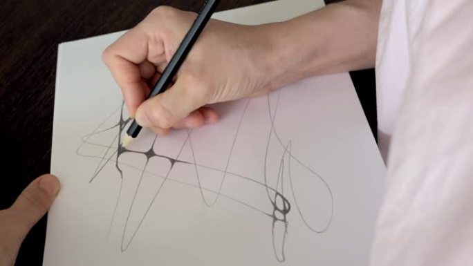 艺术家画画。俯视图设计师手中的铅笔在纸上画线，为未来的项目创建草图。建筑师在纸上的工作。神经影像学中