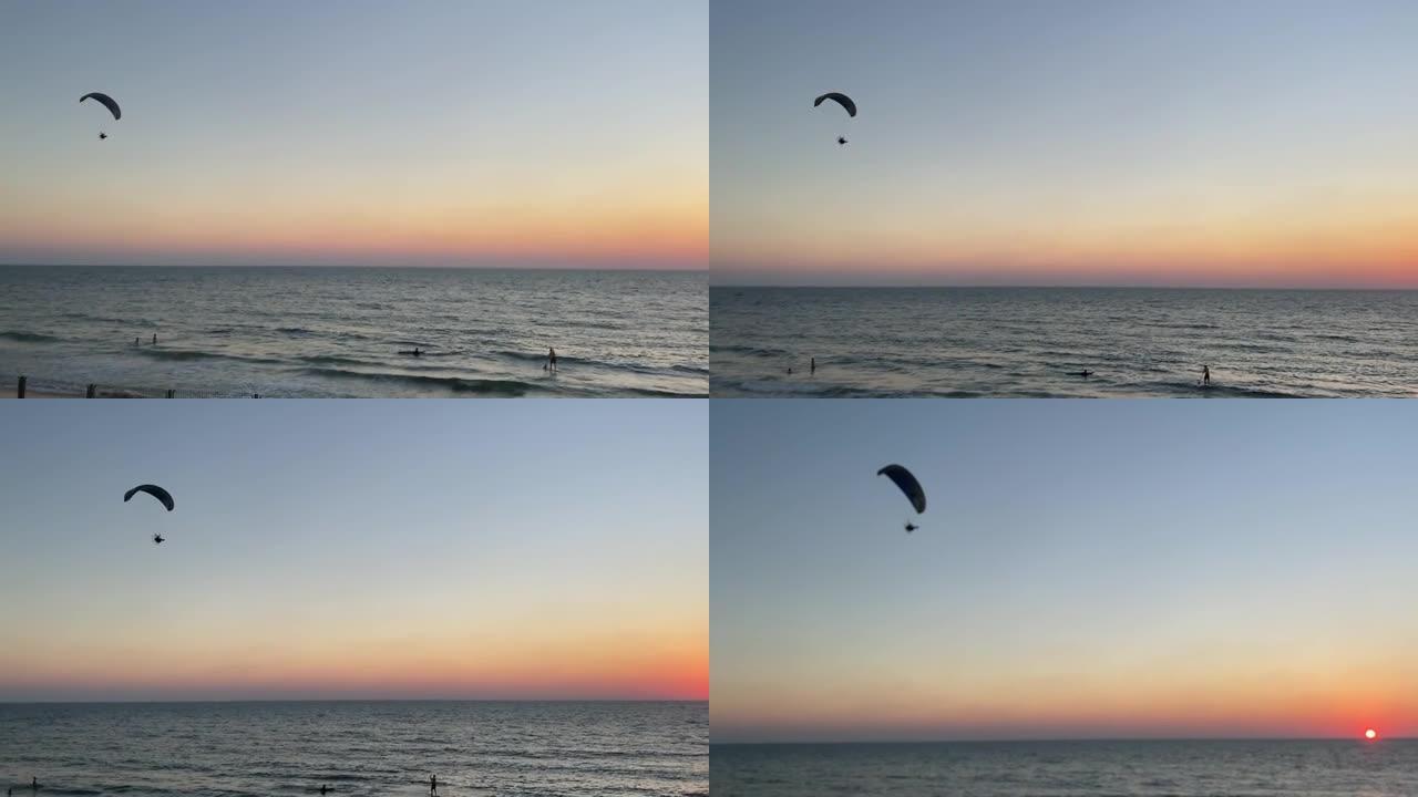 日落时海上的动力滑翔伞