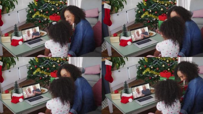 圣诞节期间，与高级夫妇在笔记本电脑上进行视频通话的非洲裔美国母女快乐