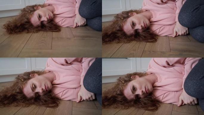 放大沮丧的年轻白人妇女躺在地板上的视频。用8k的红氦相机拍摄。