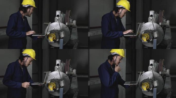 年轻的少数民族男性工人在工厂使用笔记本电脑