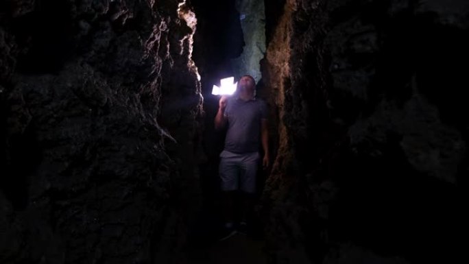 一个年轻人用火把探索一个巨大的洞穴。