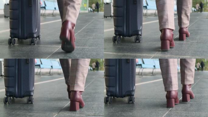 女人穿着轻便的裤子，栗色的高跟鞋，灰色的手提箱在轮子上，沿着机场航站楼和空荡荡的长椅慢慢走到户外，腿