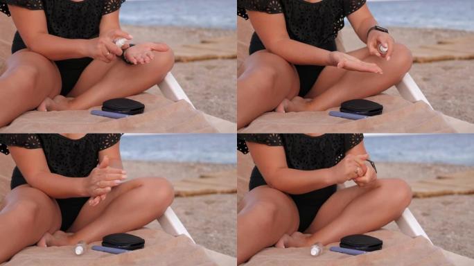 一名妇女在海滩上的贵妃椅上用洗手液喷在手上。