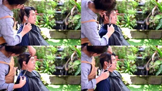 亚洲情侣理发是为了让他在家里焕然一新。花园里的沙龙和理发店。
