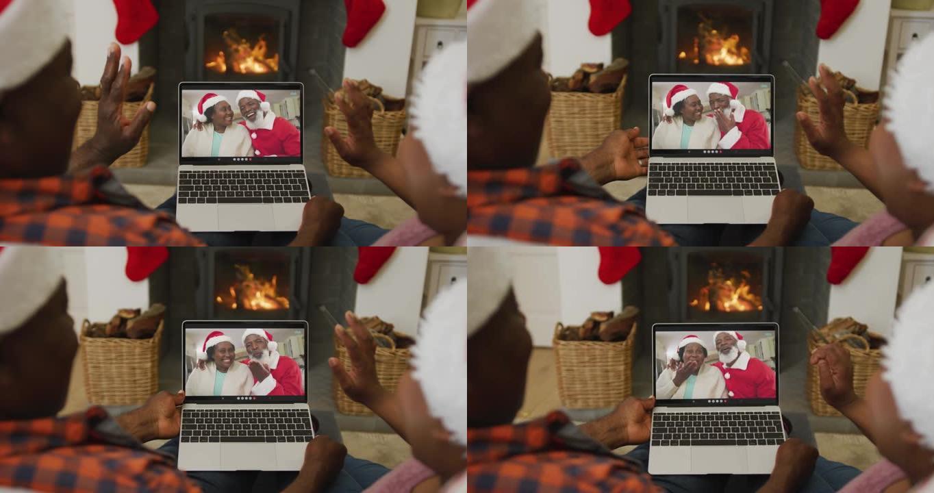戴着圣诞老人帽子的非洲裔美国夫妇使用笔记本电脑进行圣诞视频通话，屏幕上有夫妇