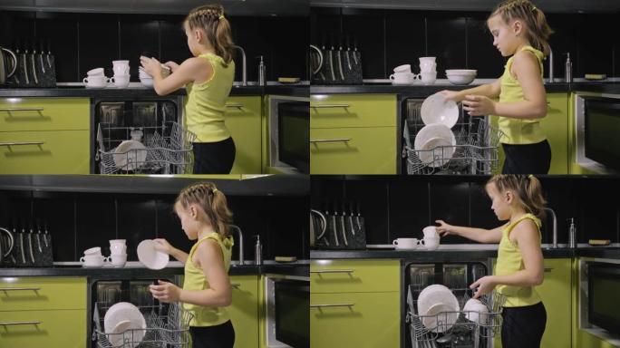 聪明的女孩学习使用洗碗机。时尚现代内置绿色黑色厨房电器。孩子正在放脏盘子