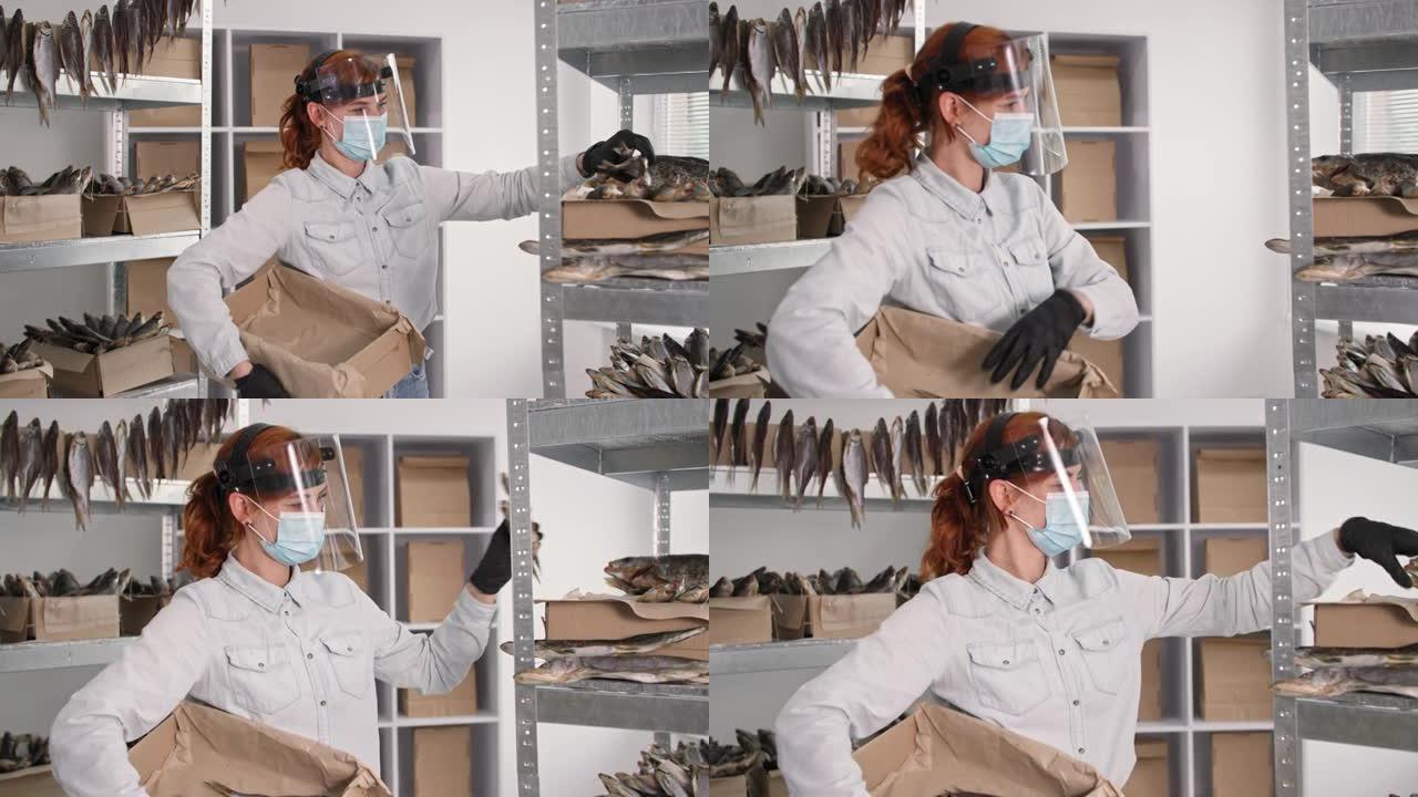 检疫工作，年轻的女人戴着医用面具，盾牌和手套把咸鱼放在仓库货架的盒子背景下