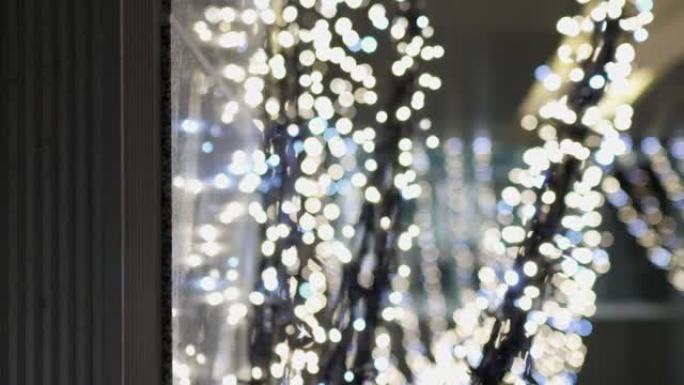 许多发光的发光二极管灯泡在室内。这些用于圣诞装饰品。卡车从左到右开枪。焦点在正面，背景模糊。主题在左