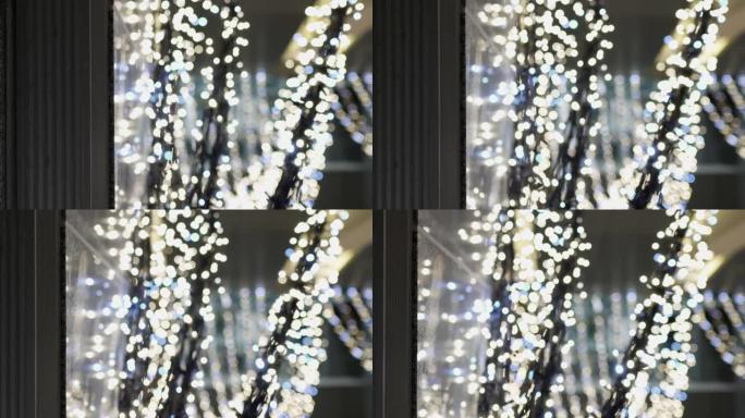许多发光的发光二极管灯泡在室内。这些用于圣诞装饰品。卡车从左到右开枪。焦点在正面，背景模糊。主题在左