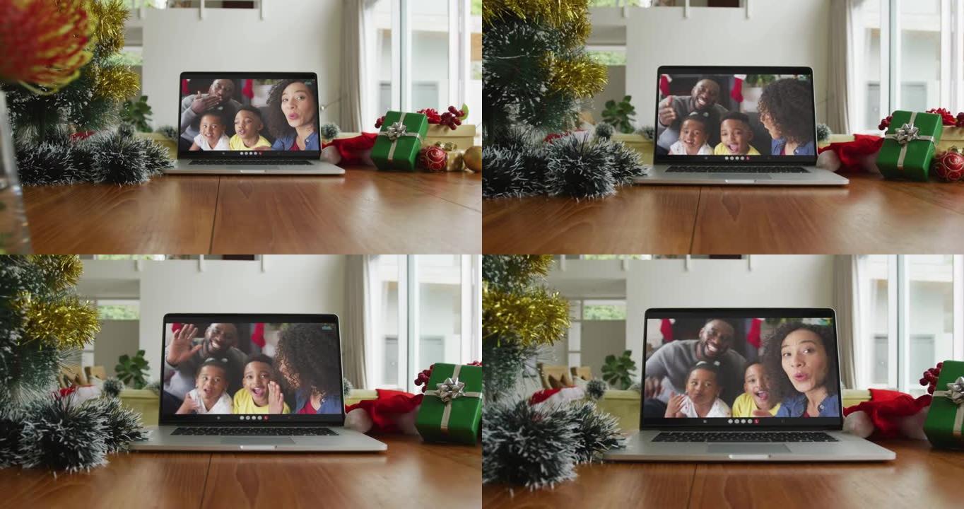微笑的非裔美国人家庭在笔记本电脑上挥舞着圣诞节视频通话