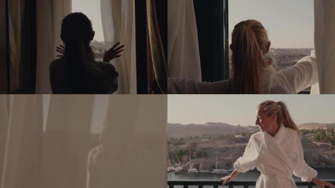 慢动作: 走向房间窗户的年轻女子打开窗帘，走到阳台上。埃及阿斯旺早上壮观的河景和帆船
