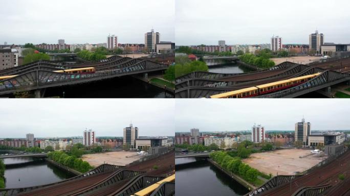 飞越城市河上的钢桥。在多轨铁路上运行的郊区火车。背景中的居民区。德国柏林