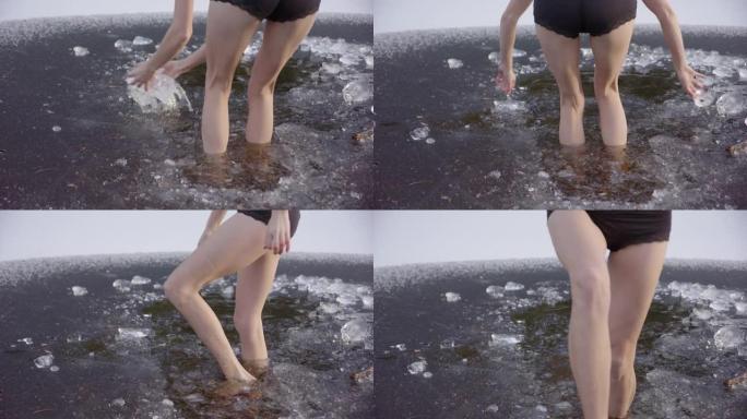 慢动作-年轻女子的美丽腿走进冰冷的水中，跳了出来