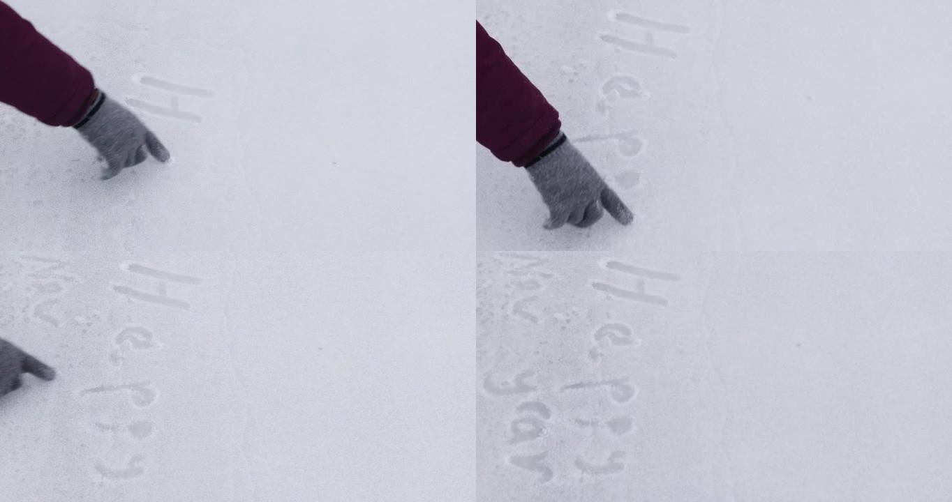 戴着手套的快乐女孩在冰上写字，撒上雪铭文新年快乐，水平