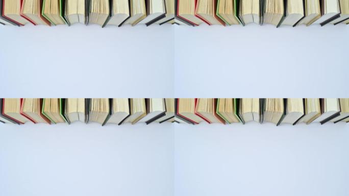 一堆不同颜色的精装书出现在书架上，有空的文字空间。停止运动平铺