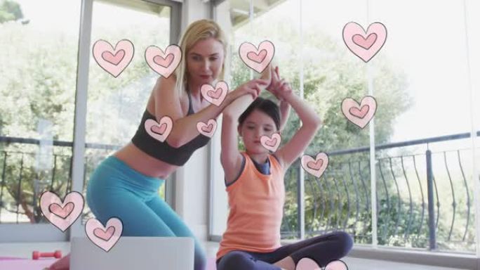 心脏在快乐的高加索女人身上移动的动画，她的女儿用笔记本电脑做瑜伽