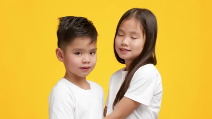 日本小弟弟和妹妹拥抱在黄色背景上