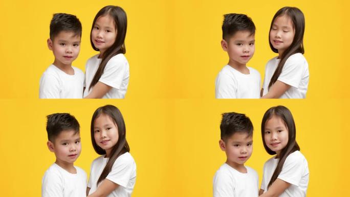 日本小弟弟和妹妹拥抱在黄色背景上