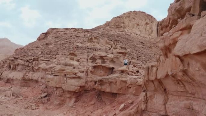 在红岩沙漠中运动的带运动瑜伽球的女人的无人机飞行视图