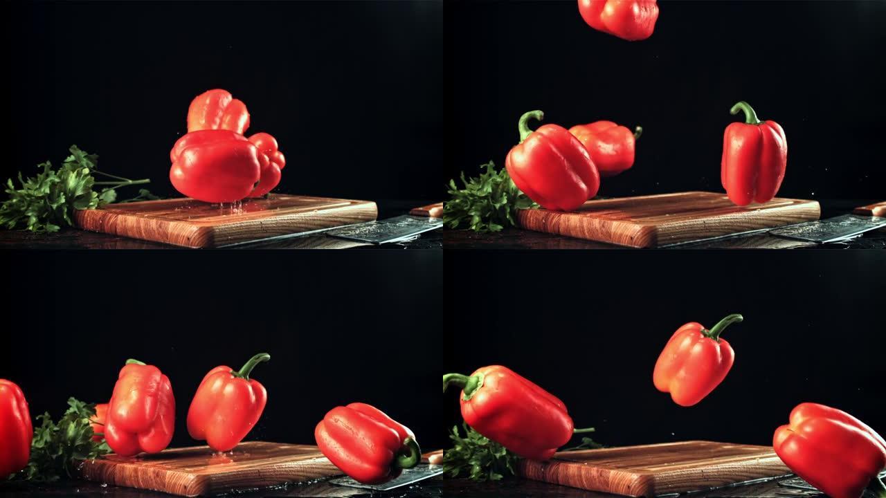 成熟的甜椒落在木制砧板上。拍摄的是1000 fps的慢动作。