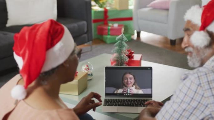 快乐的非洲裔美国高级夫妇在圣诞节与家人进行笔记本电脑视频通话
