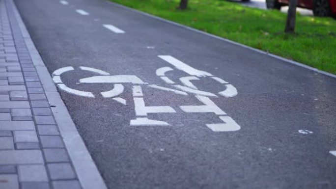 自行车车轮的旋转。骑自行车。自行车道上的自行车标志。男孩在自行车道上踩自行车