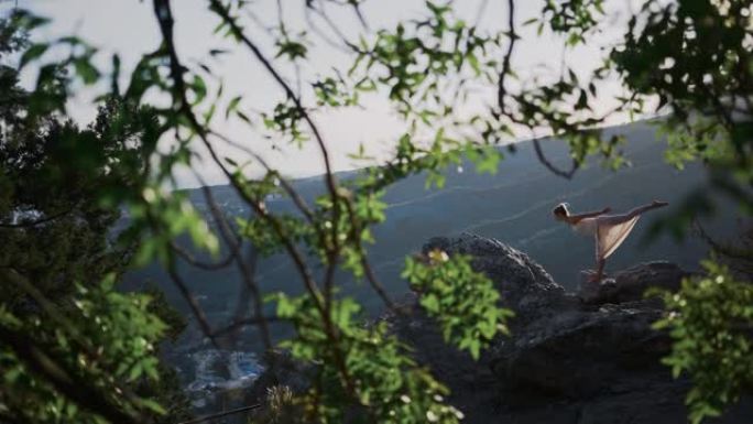 一位身穿白色长裙的年轻女子站在悬崖上，摆出瑜伽姿势