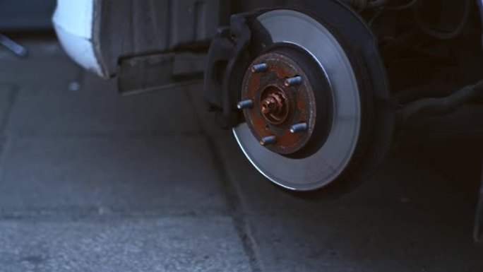 车库车间轮胎更换过程中暴露的带有制动盘和制动片的汽车轮毂