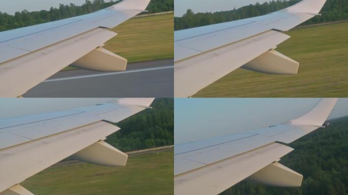 从地面起飞的飞机机翼视图。离开地面，从飞机窗户看