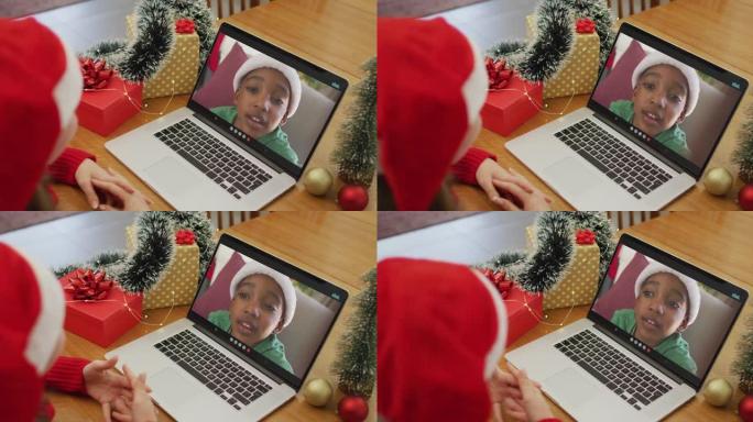 在圣诞节期间与非洲裔美国男孩进行视频通话的白人妇女