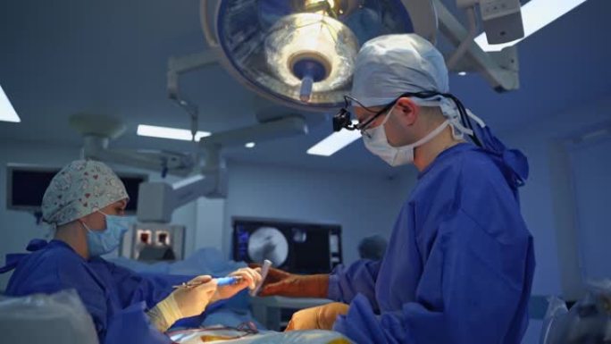 护士在手术期间协助外科医生。医疗制服的专业医生在医院用无菌手术器械进行手术。