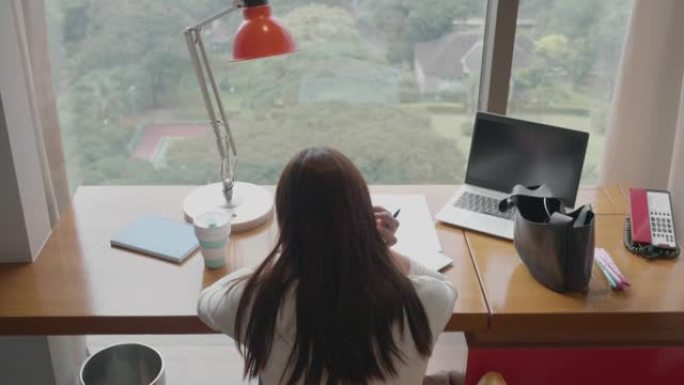 东南亚妇女在家中使用笔记本电脑工作