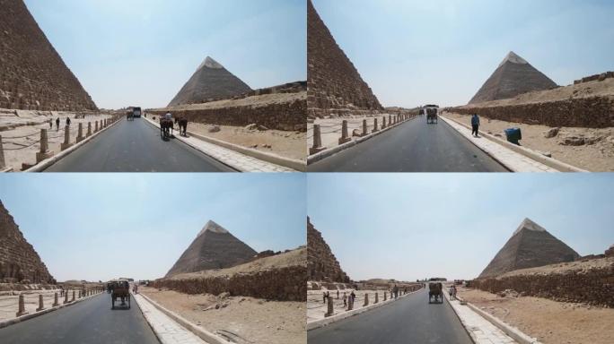 在埃及Cheops金字塔附近的吉萨乘坐马车的游客