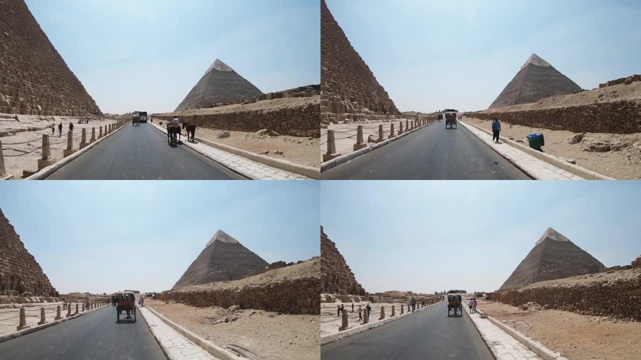 在埃及Cheops金字塔附近的吉萨乘坐马车的游客