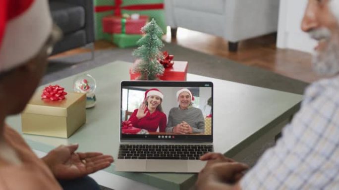 快乐的非洲裔美国高级夫妇在圣诞节与高级朋友进行视频通话
