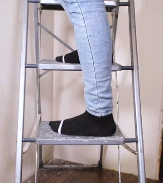 年轻女性设计师爬上梯子。公寓装修概念
