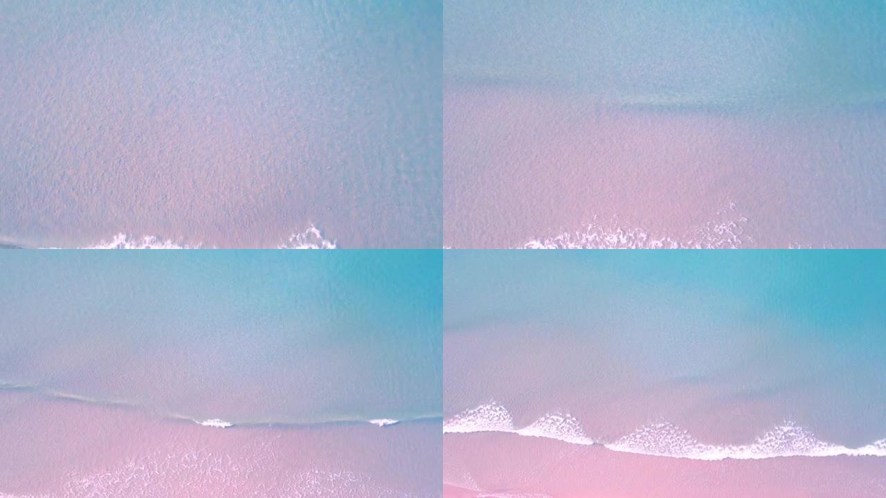 无人机、蓝色海浪和美丽的粉色沙滩的4k鸟瞰图。