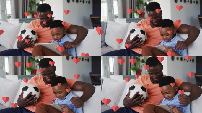 在家里的沙发上使用智能手机在快乐的非洲裔美国父子身上的红心动画