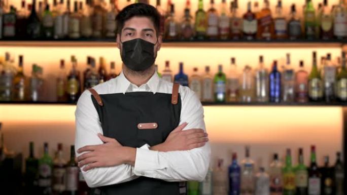 调酒师在冠状病毒大流行新常态期间戴着防护口罩。高质量4k镜头
