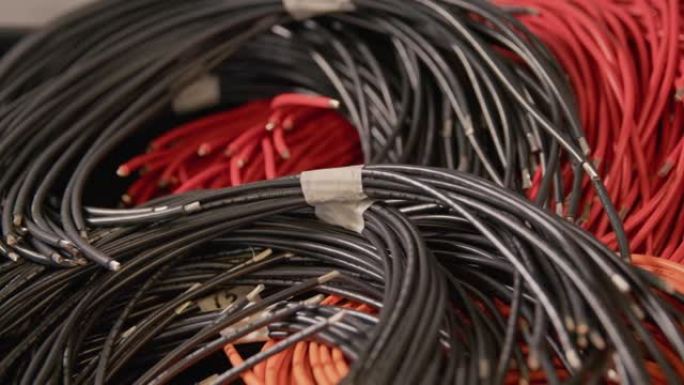 一堆卷起的红色和黑色电缆