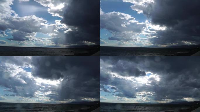 下雨时的海景。太阳光线冲破暴风云。雨滴落在相机镜头上。雷云覆盖天空，开始下雨，暴风雨前的自然。全高清
