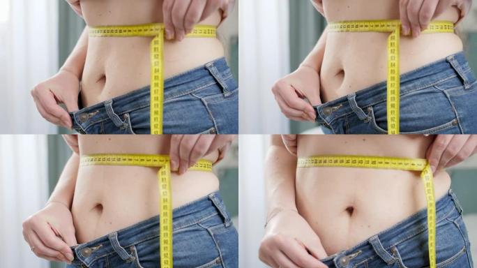 年轻女子减肥后测量腰部的特写镜头。节食、减肥和健康的生活方式的概念。